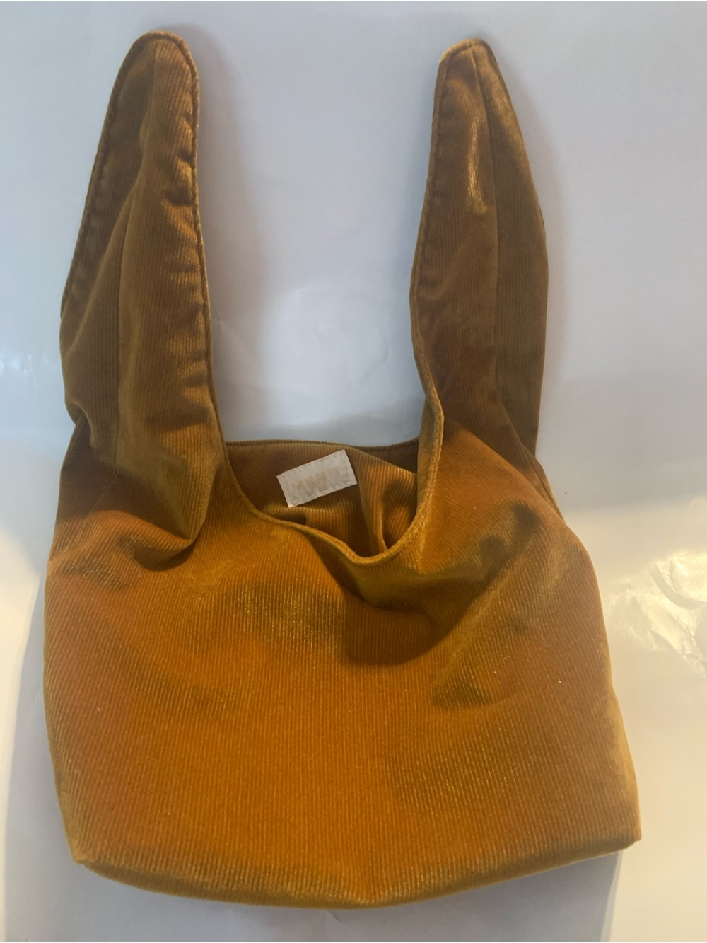 Merit Beauty Signature Bag in a golden brown or camel corduroy material